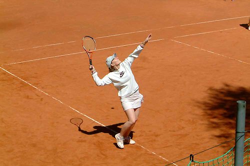 Erhöhter Blick auf eine Tennisspielerin, als sie gerade nach einem Ball schlägt Tennis lernen im Bayerischen Wald.